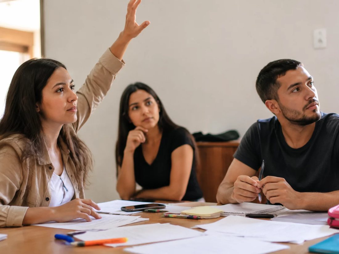 Dupla preparando a rodada seguinte com cadernos e marcadores espalhados na mesa